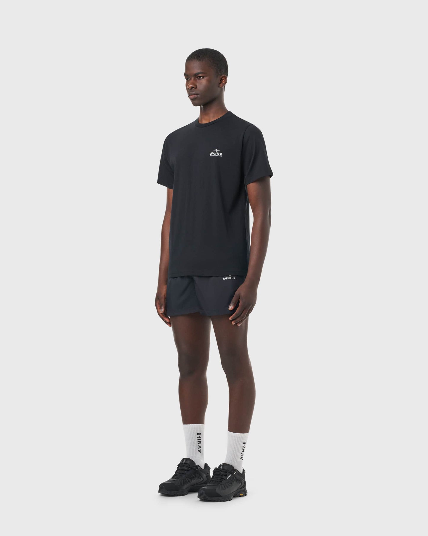 T-shirt noir Avnier Source Black Chrome Vertical porté par un homme, vue de profil, look urbain et décontracté.