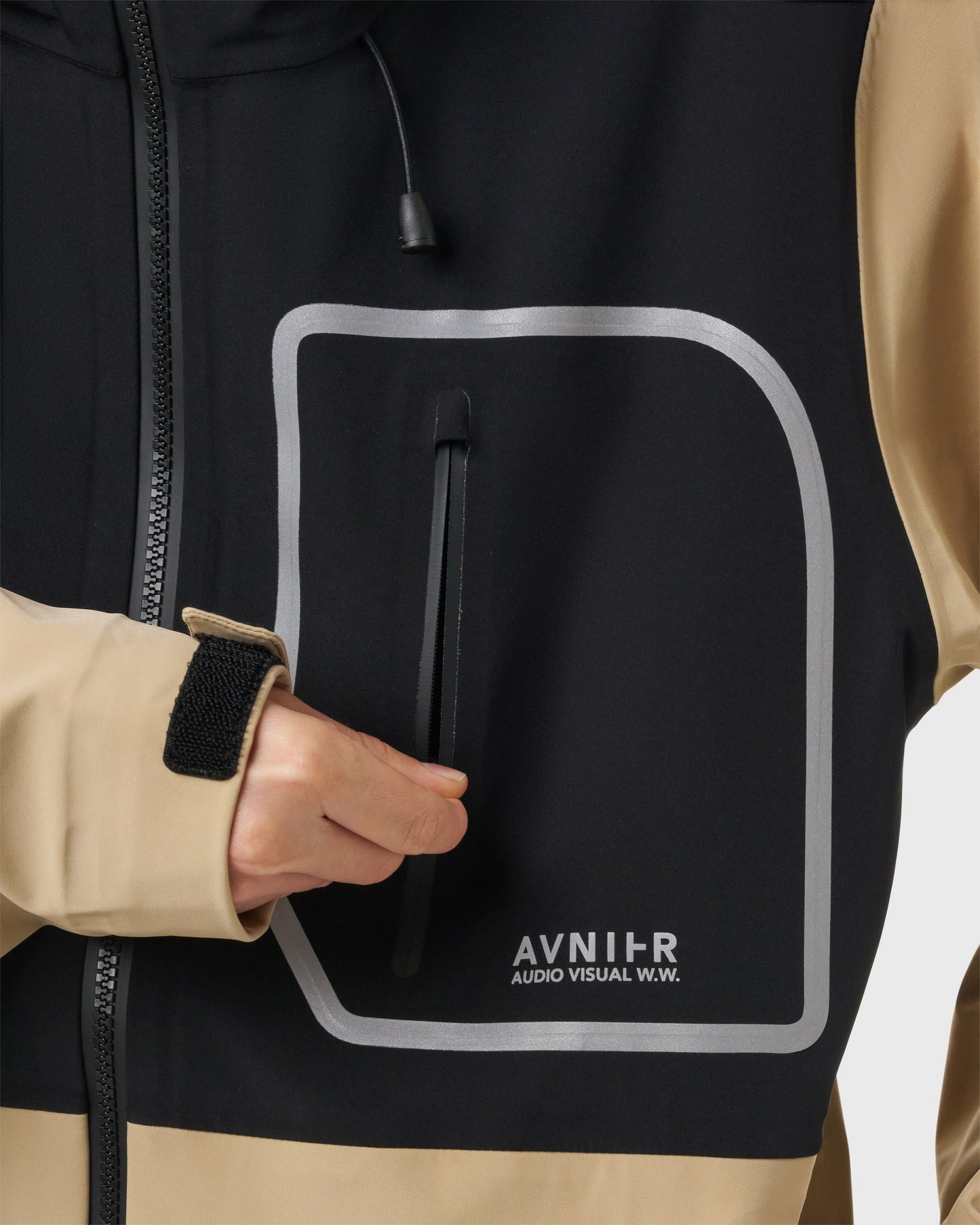 Détail de la poche poitrine zippée sur la veste beige Avnier Interlude, bande réfléchissante visible. - beige