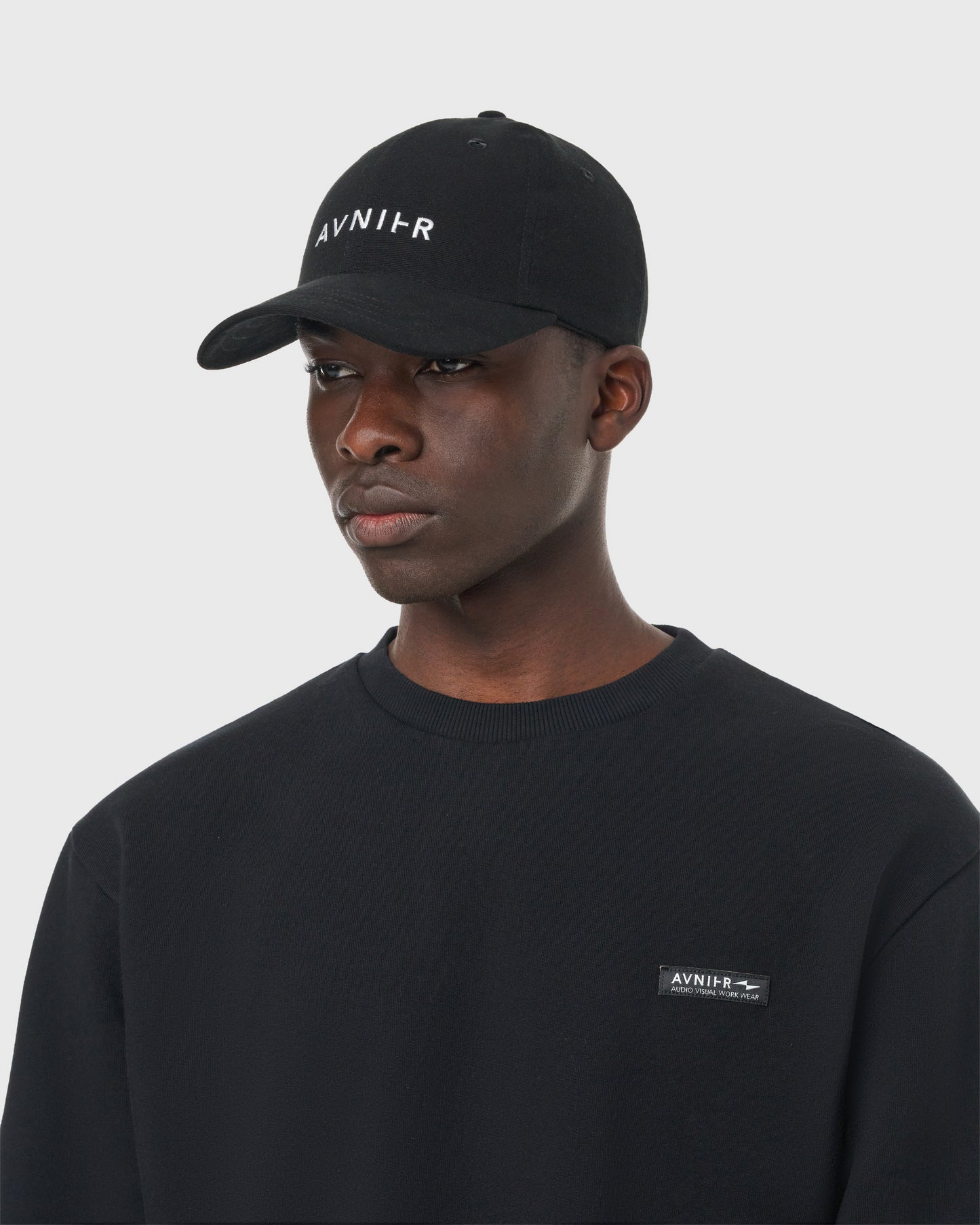 Casquette noire Avnier Focus V2 portée, vue frontale — look casual et minimaliste.