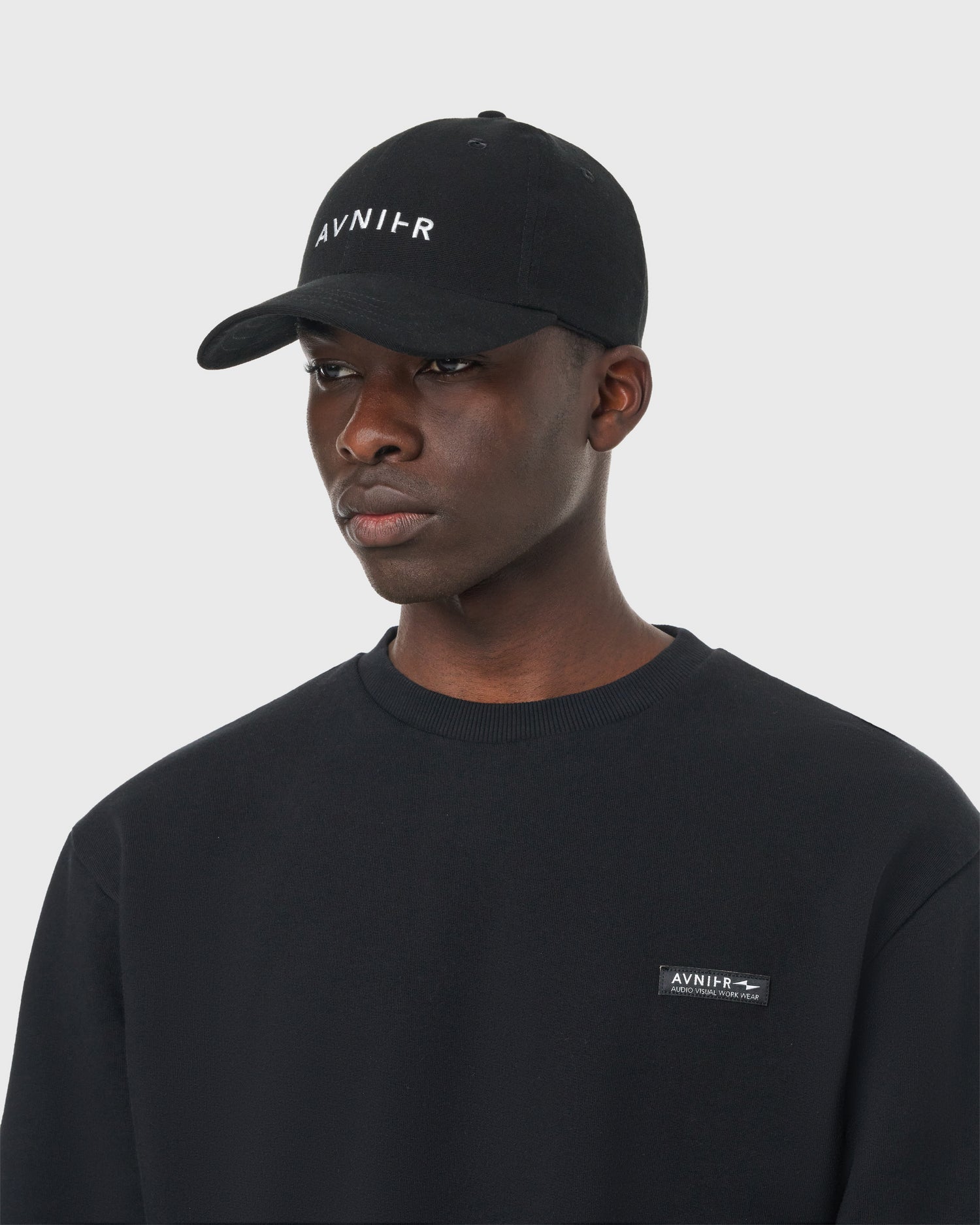 Casquette noire Avnier Focus V2 portée, vue frontale — look casual et minimaliste.