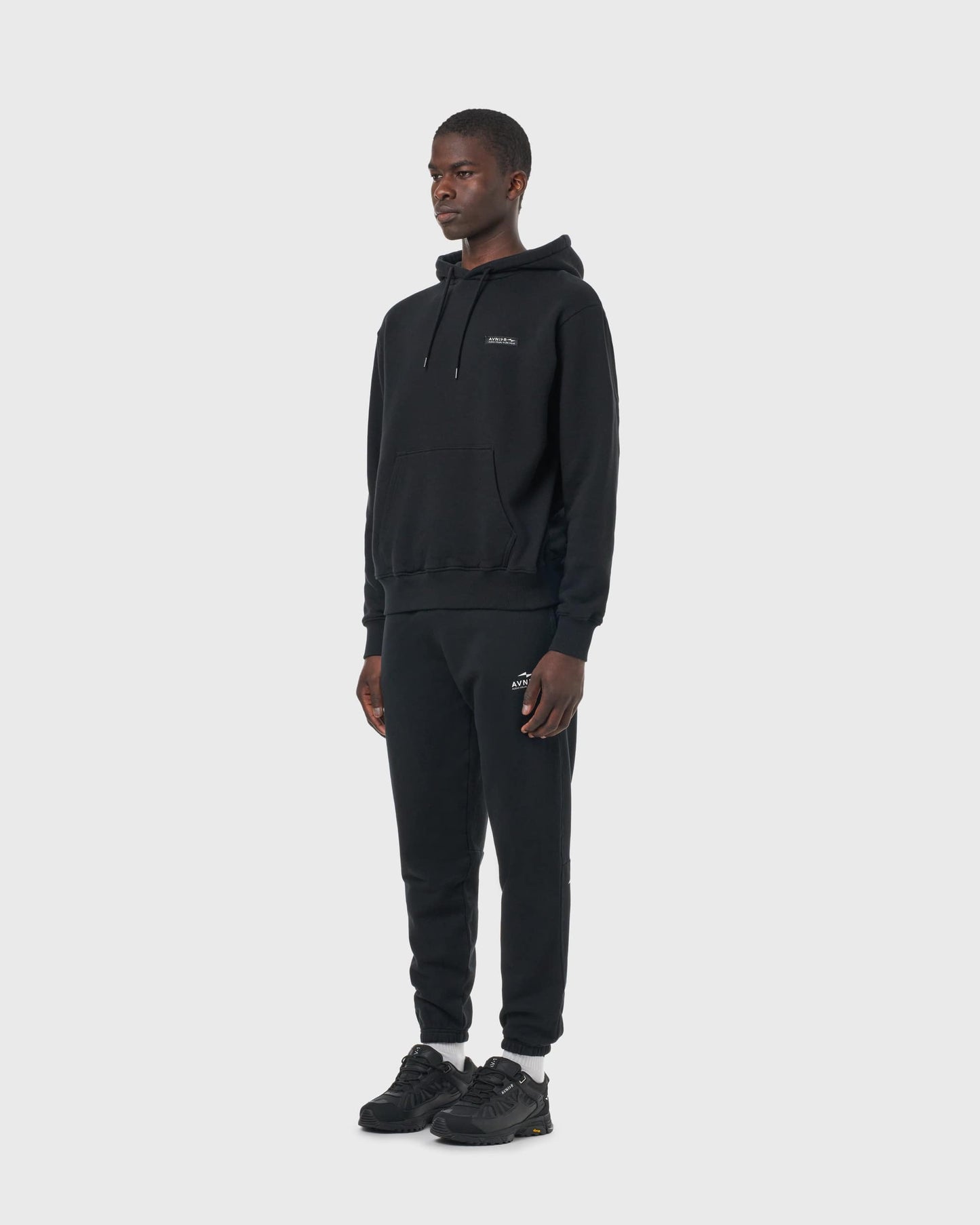 Hoodie noir Avnier Onset V5 vu de profil, coupe droite et finitions soignées.