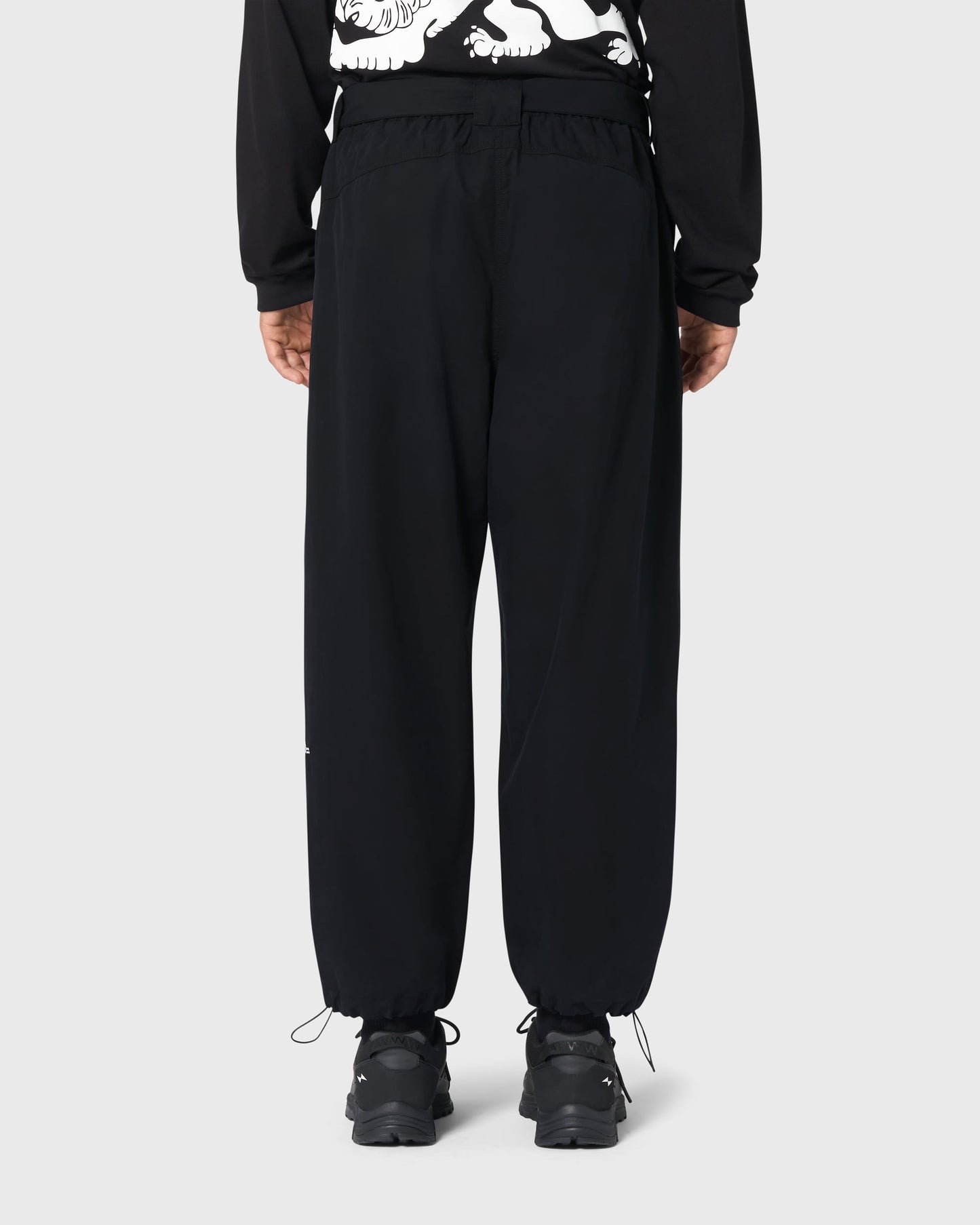 Pantalon Housaka AVNIER × Saint James noir porté de dos, détails visibles de la poche arrière et broderie Mont sur la jambe gauche.