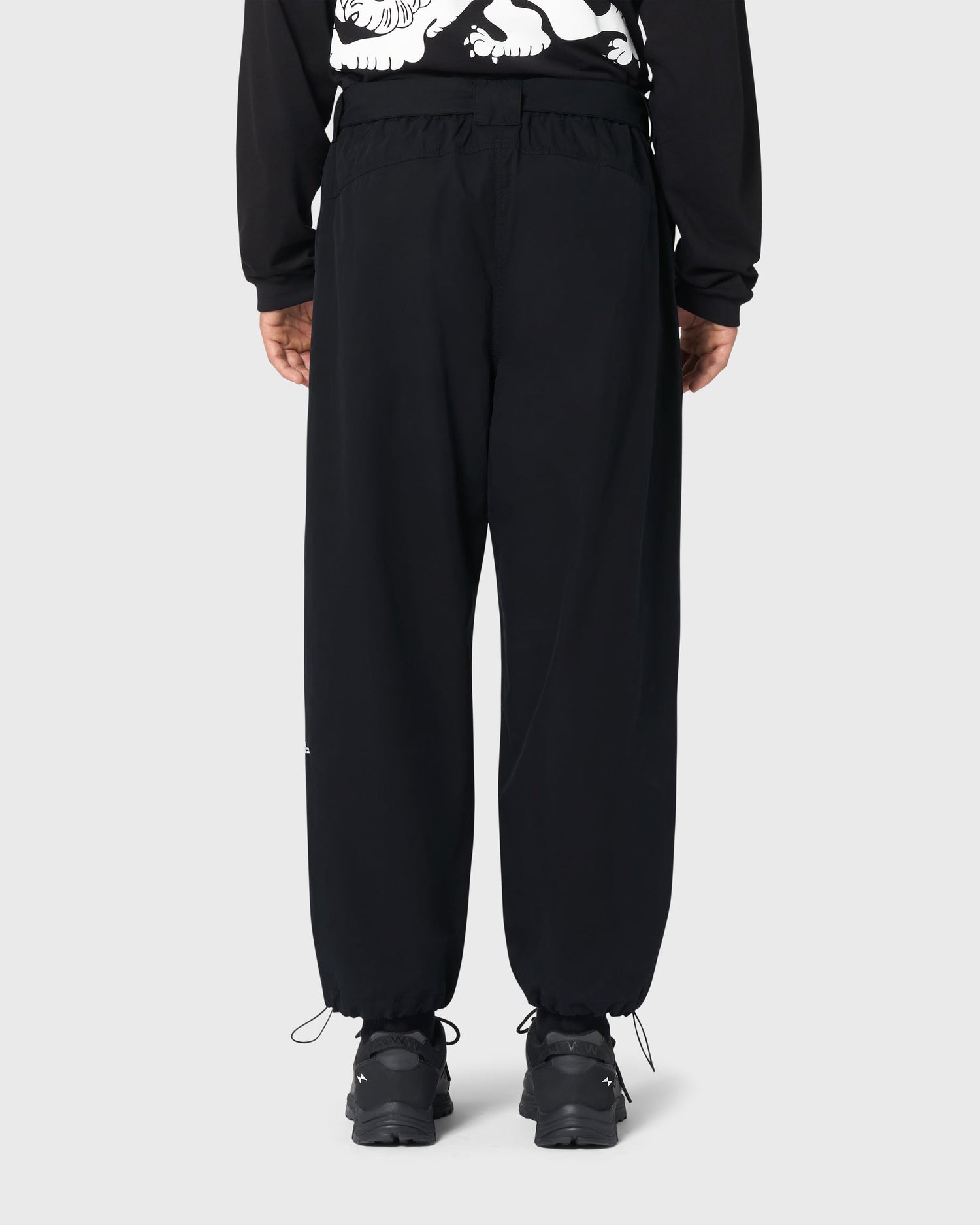 Pantalon Housaka AVNIER × Saint James noir porté de dos, détails visibles de la poche arrière et broderie Mont sur la jambe gauche.