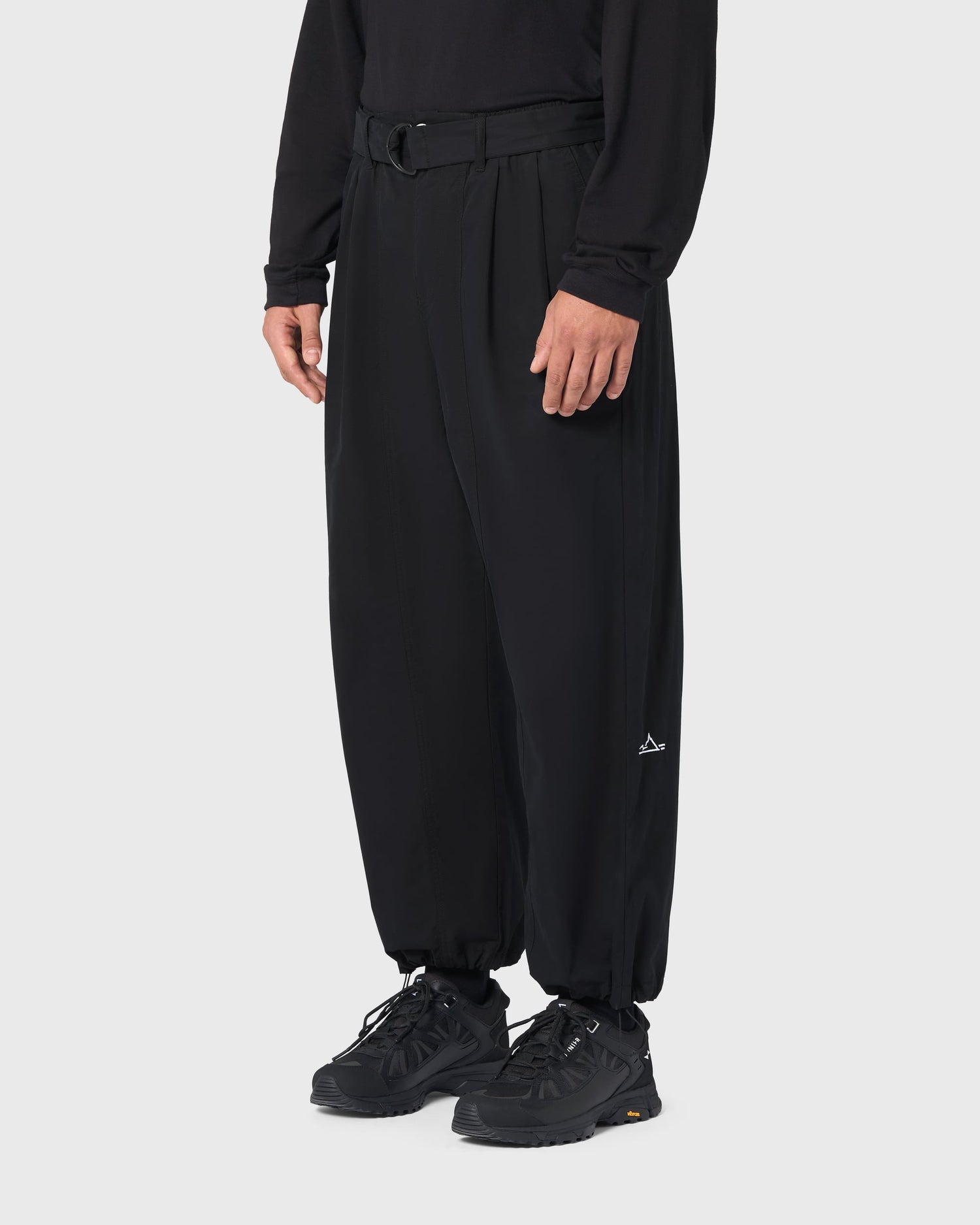 Pantalon Housaka AVNIER × Saint James noir porté de profil, coupe large et bas de jambe resserrables par cordons.