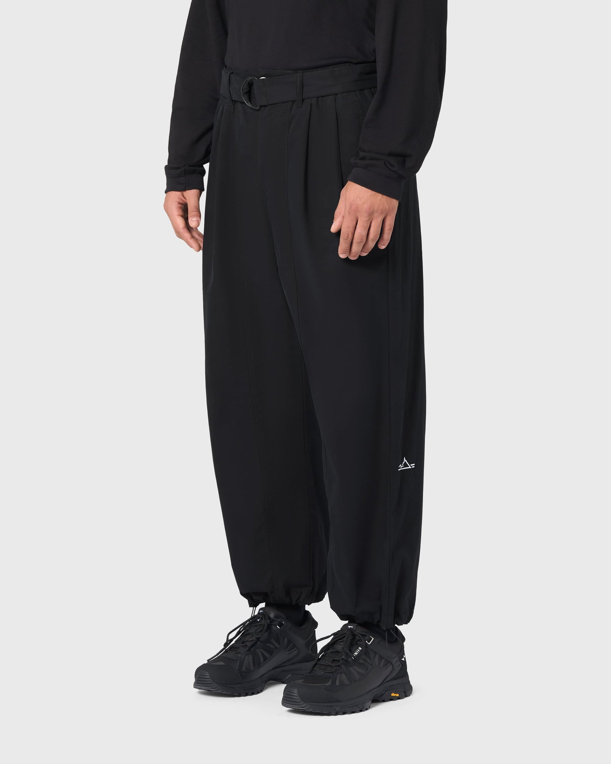 Pantalon Housaka AVNIER × Saint James noir porté de profil, coupe large et bas de jambe resserrables par cordons.