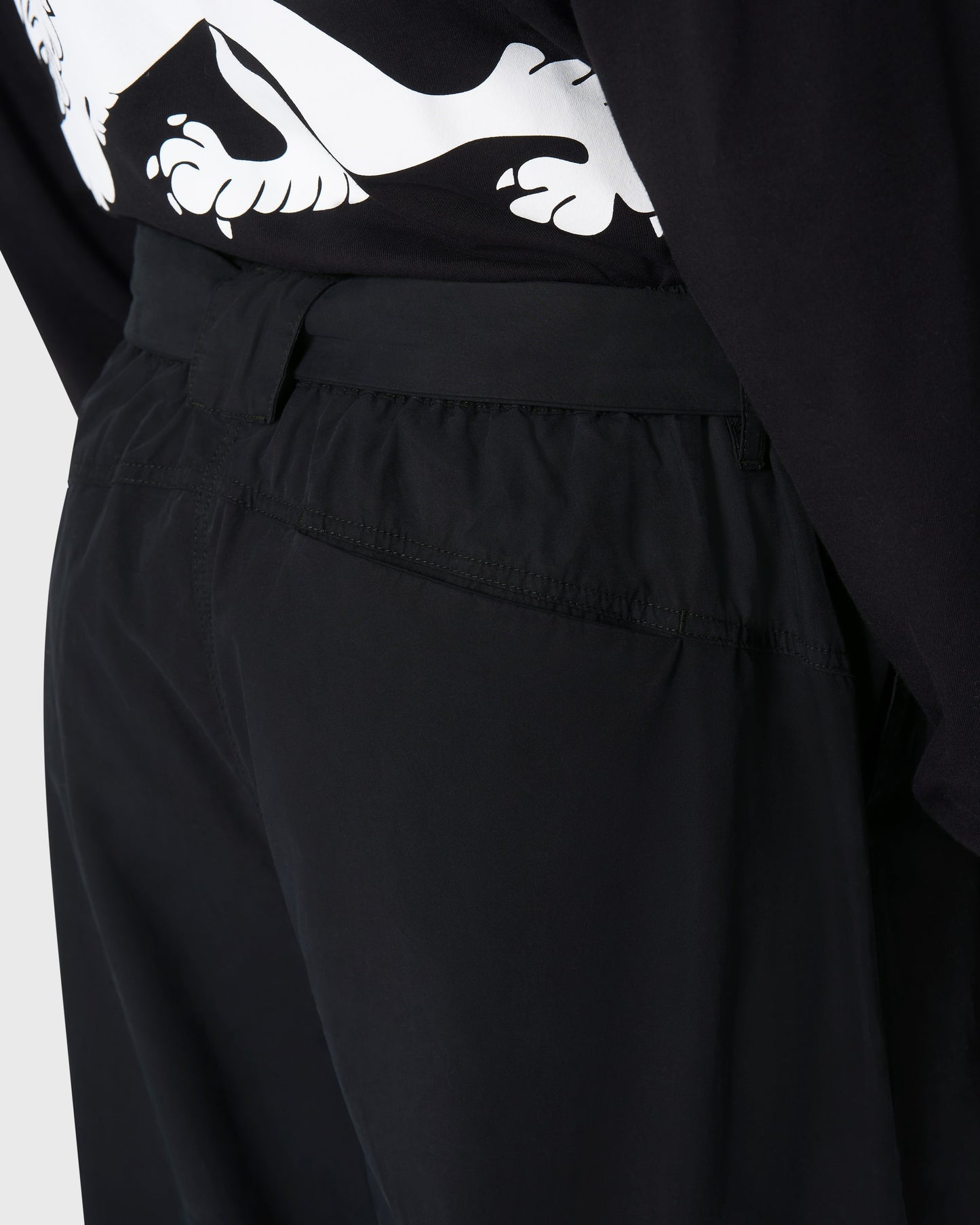 Zoom sur la poche arrière du pantalon Housaka AVNIER × Saint James noir, détail de la ceinture technique et de la couture en toile parachute.