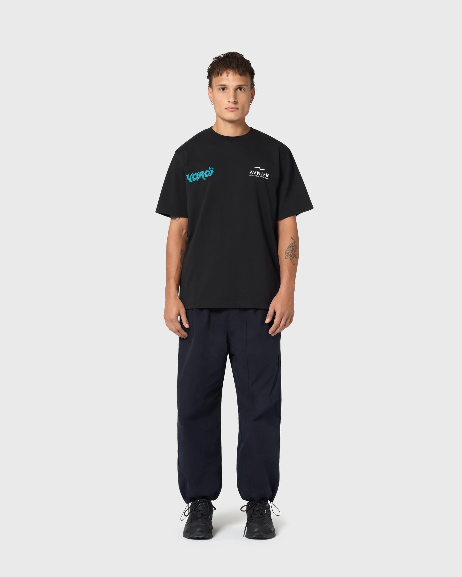 T-shirt AVNIER Yoroï noir porté, coupe droite et sérigraphie bleu vif, mélange d’influences urbaines et cinématographiques.