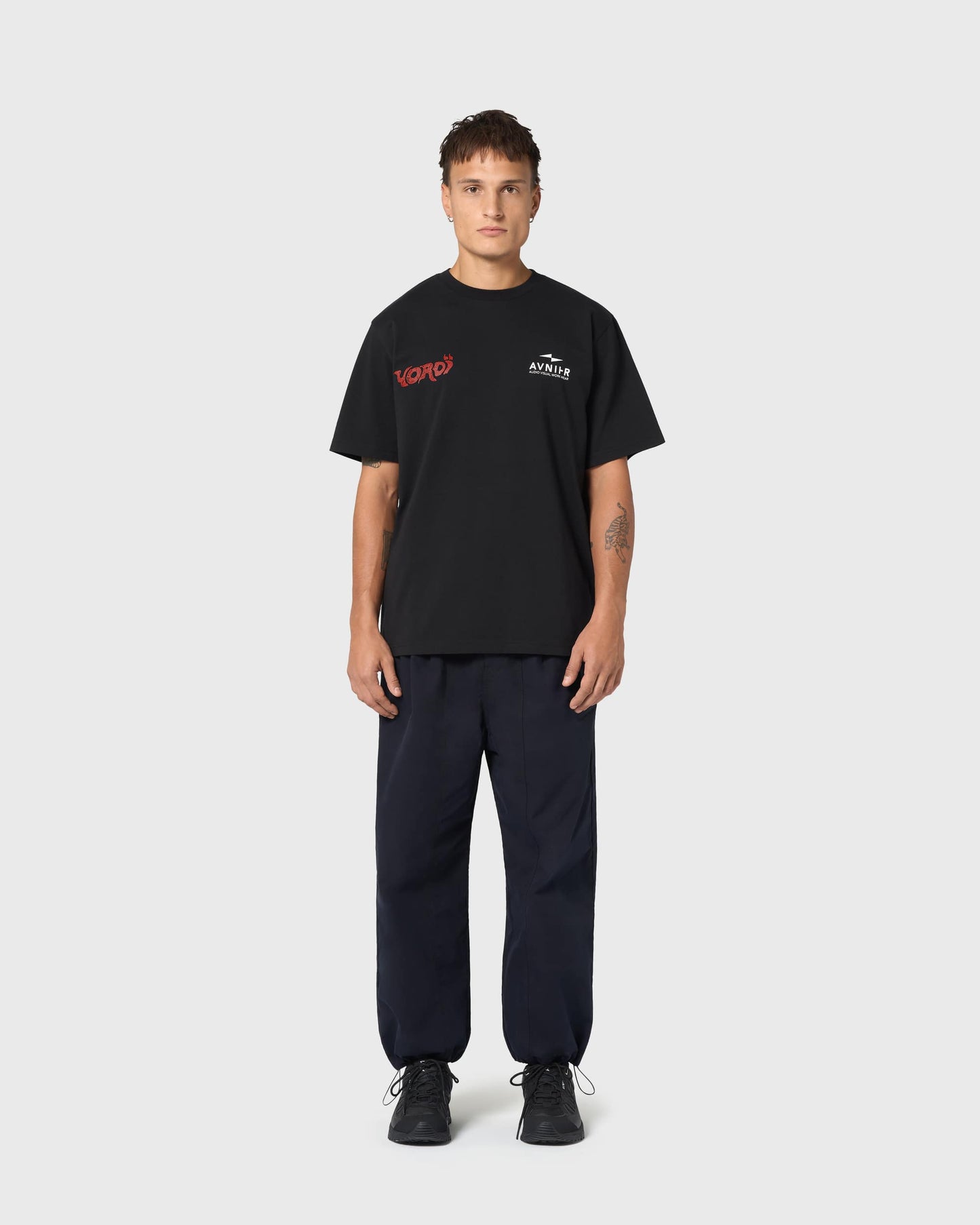 T-shirt noir AVNIER × Yoroï porté, sérigraphie rouge contrastée, esthétique urbaine et influence audiovisuelle japonaise.