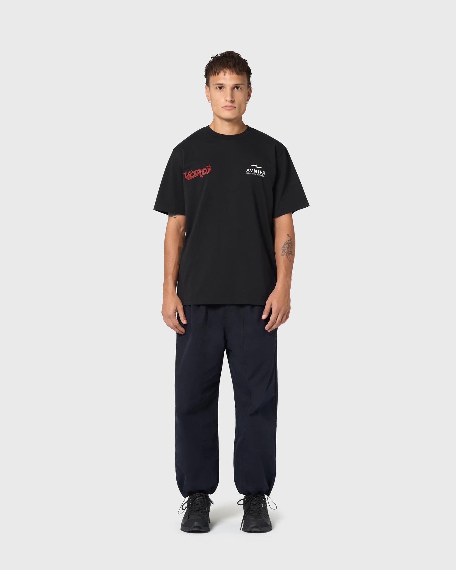 T-shirt noir AVNIER × Yoroï porté, sérigraphie rouge contrastée, esthétique urbaine et influence audiovisuelle japonaise.