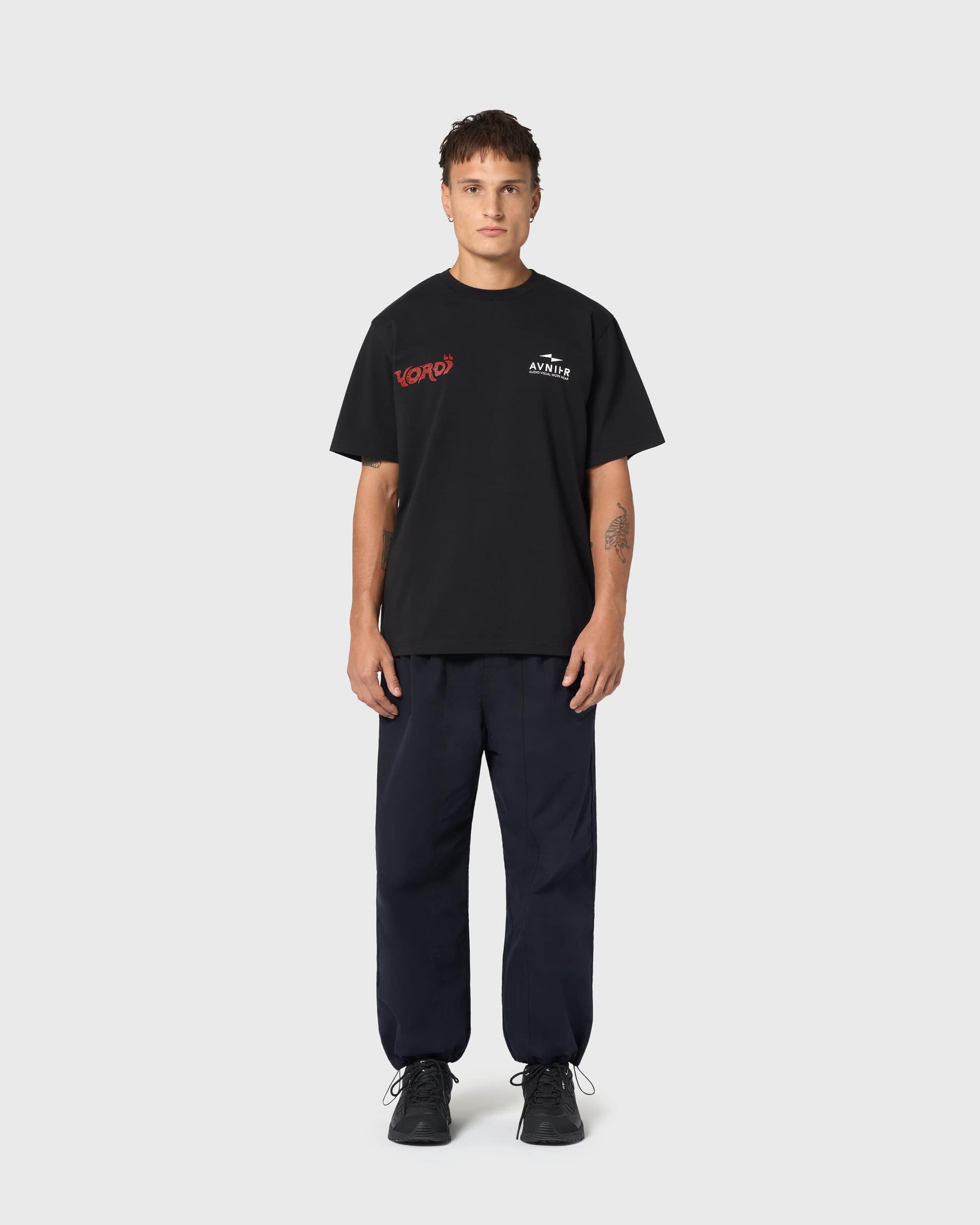 T-shirt noir AVNIER × Yoroï porté, sérigraphie rouge contrastée, esthétique urbaine et influence audiovisuelle japonaise.