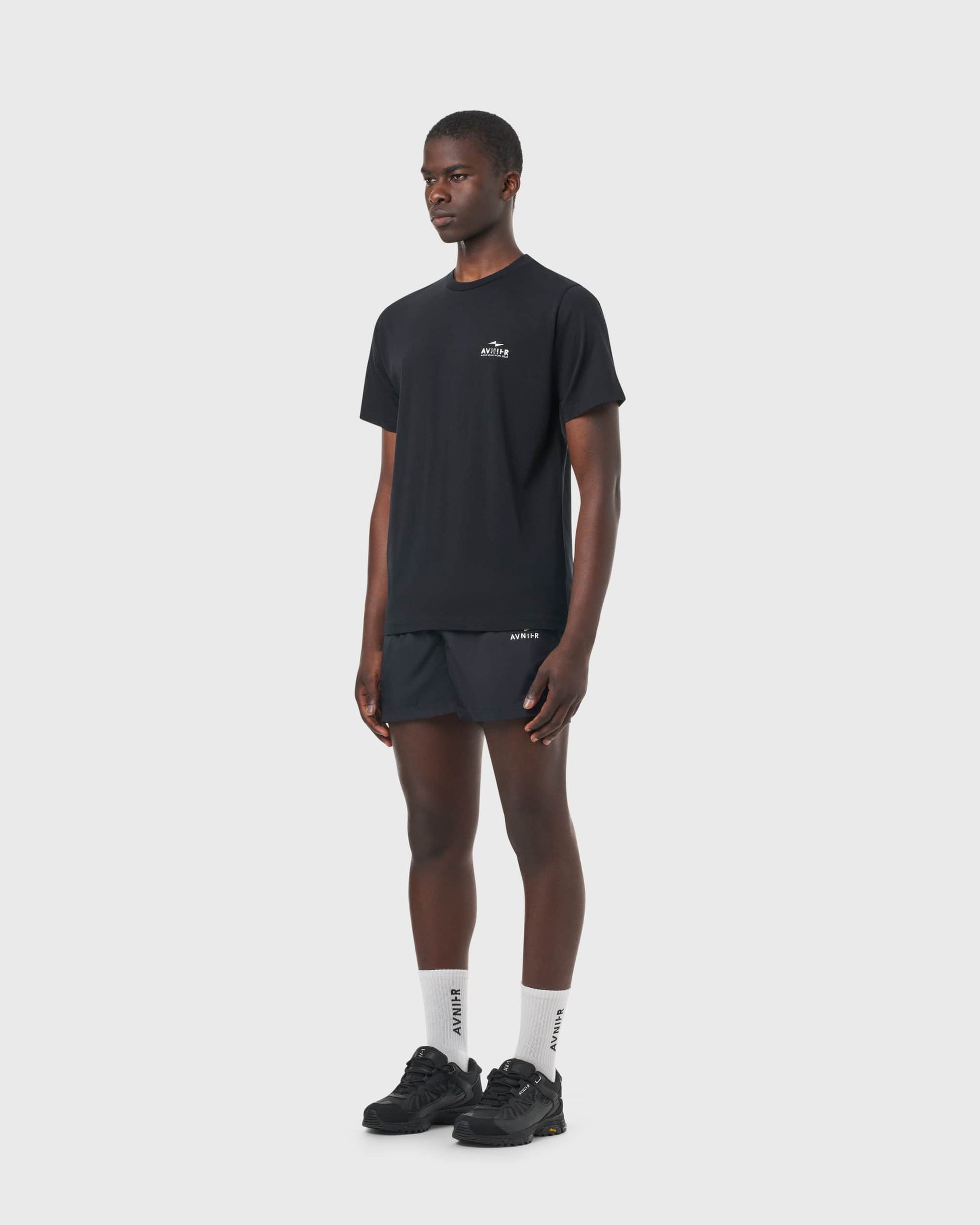 T-shirt noir Avnier Source Black Chrome Vertical porté par un homme, vue de profil, look urbain et décontracté.