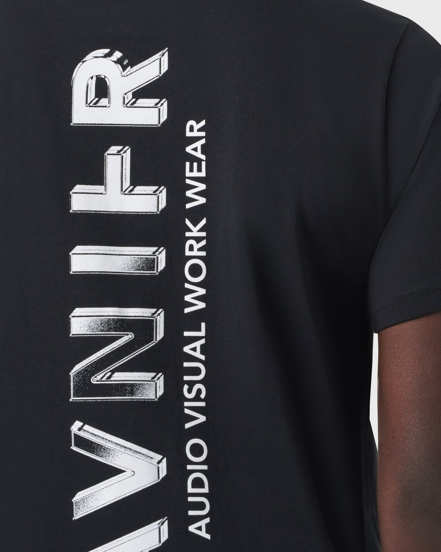 Zoom sur le grand logo vertical Avnier sérigraphié au dos du T-shirt noir.