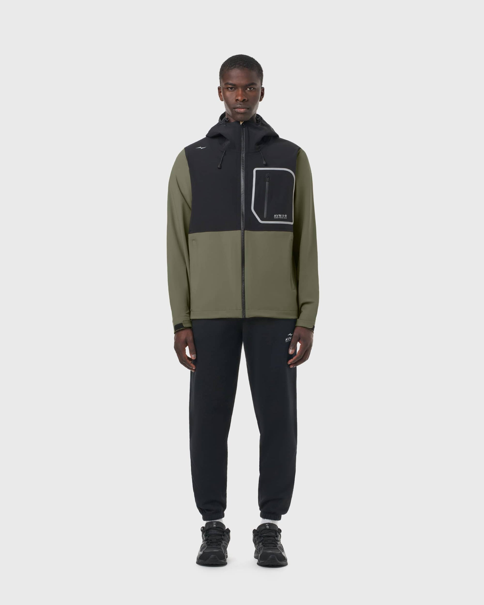 Veste Hardshell Avnier kaki portée par un homme, vêtement technique imperméable pour métiers de l’audiovisuel. - kaki