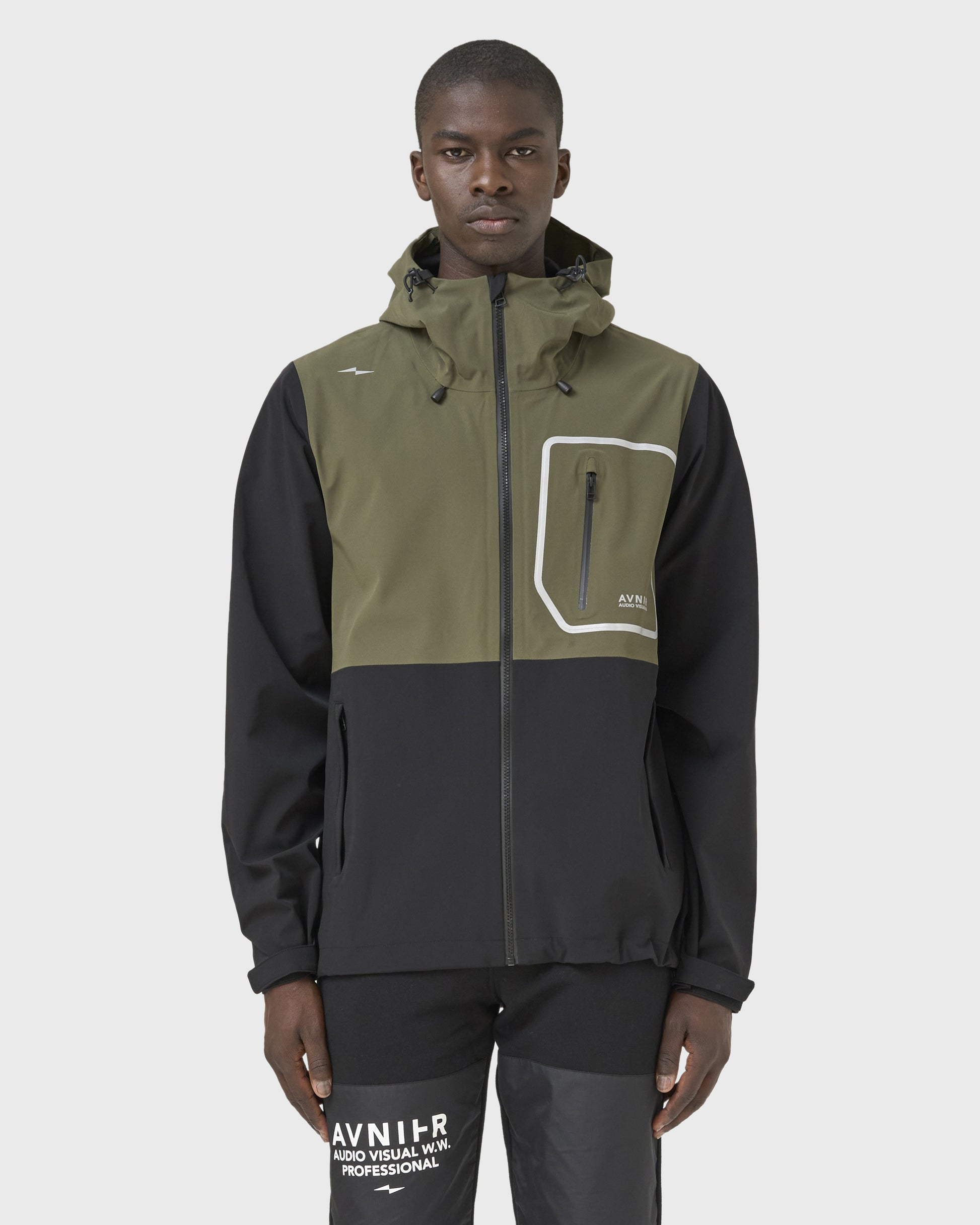 Veste Hardshell Avnier kaki portée par un homme, vêtement technique imperméable pour métiers de l’audiovisuel. - kaki