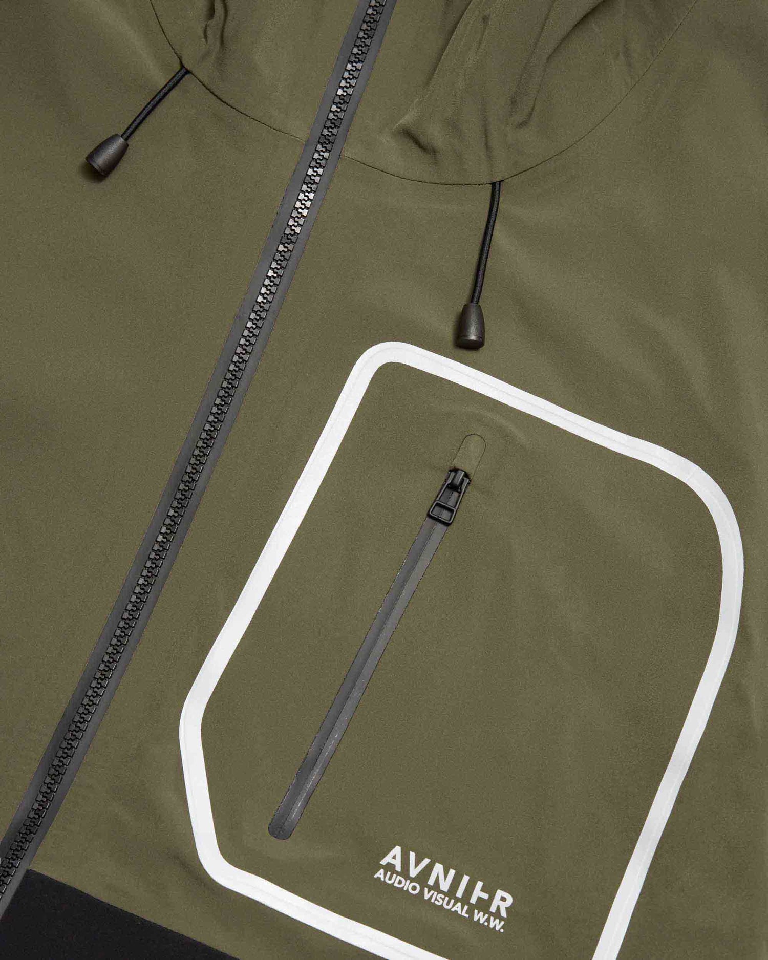 Détail de la poche poitrine zippée de la veste Avnier Interlude kaki, finition réfléchissante et pratique. - kaki